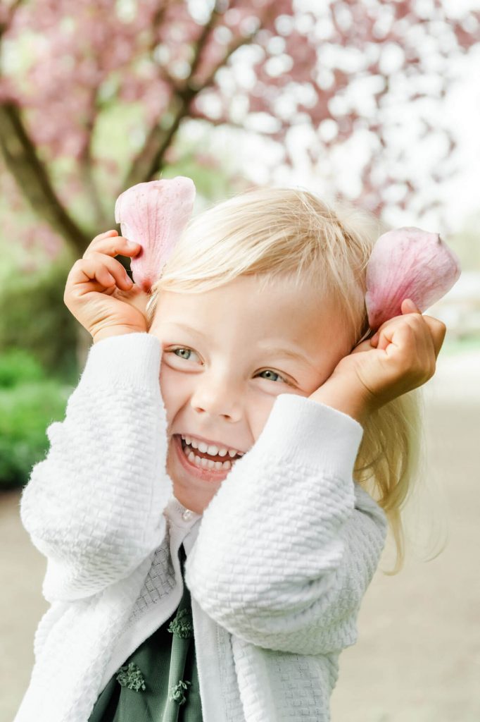 Lachendes Kind mit Blütenohren im Frühling