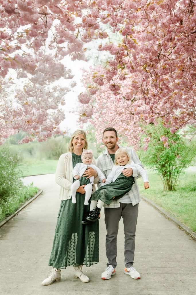 Familie unter blühenden Kirschbäumen im Frühling