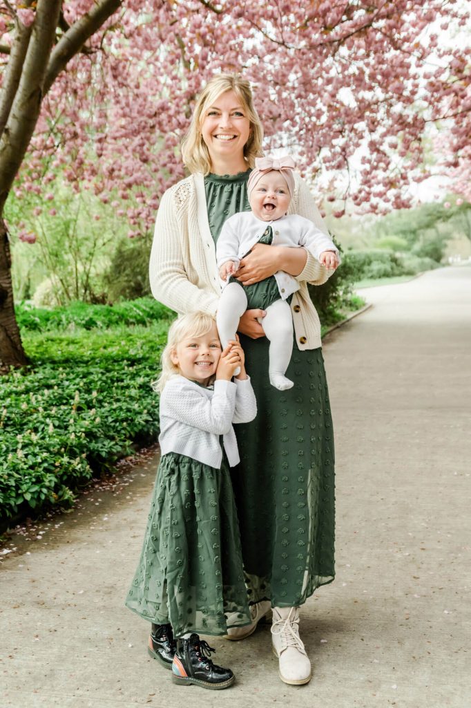 Glückliche Familie im Park unter blühenden Bäumen