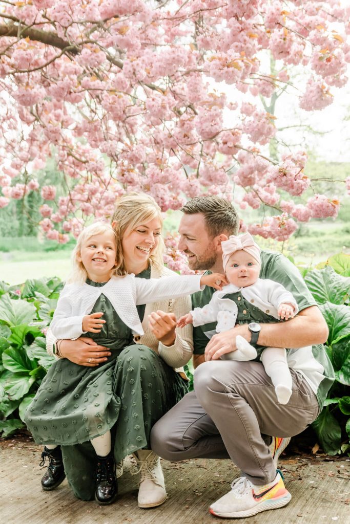 Familie genießt Frühlingstag unter Kirschblütenbaum