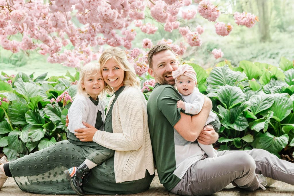 Glückliche Familie im Garten mit Kirschblüten