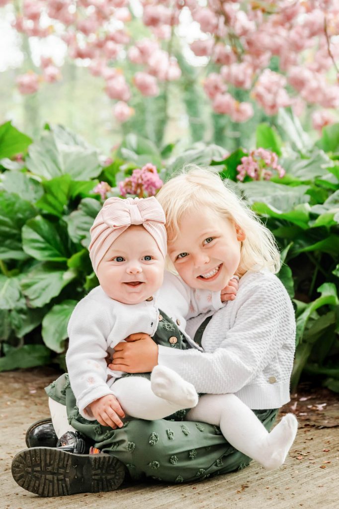Zwei lächelnde Kinder im blühenden Garten