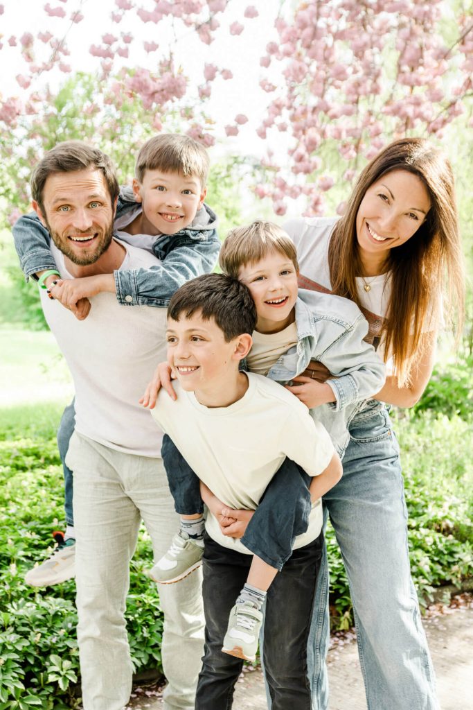 Glückliche Familie im sonnigen Frühlingsgarten lächelnd