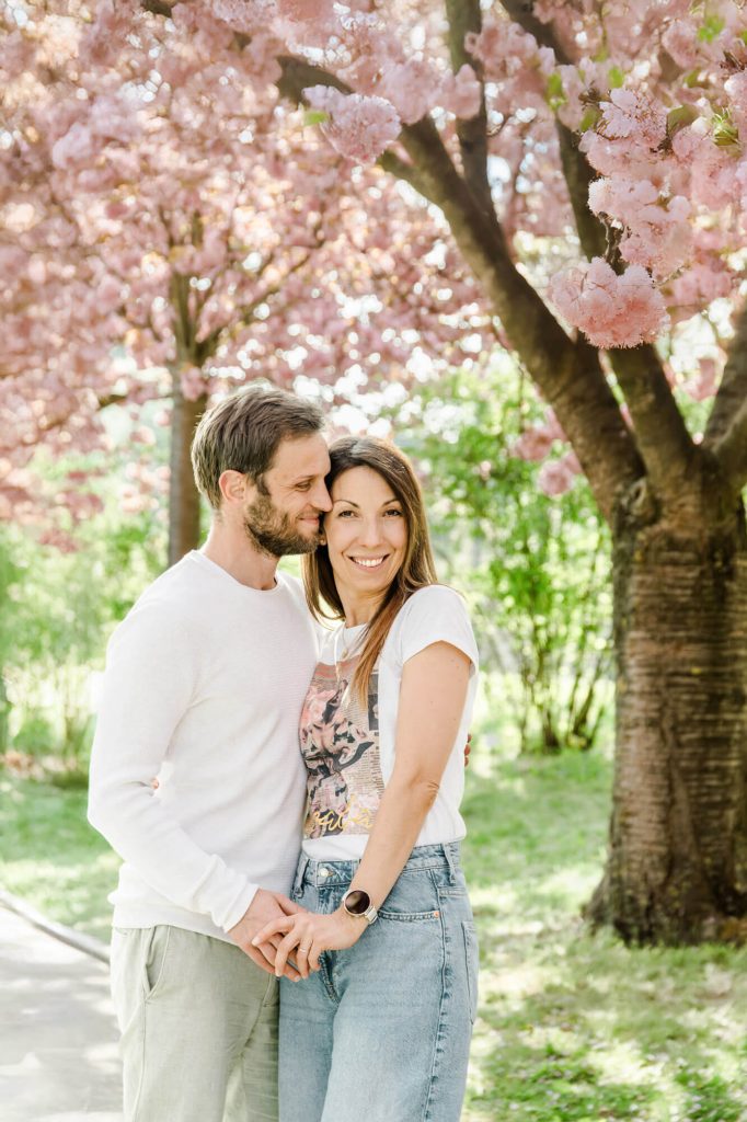 Paar unter blühenden Kirschbäumen im Frühling