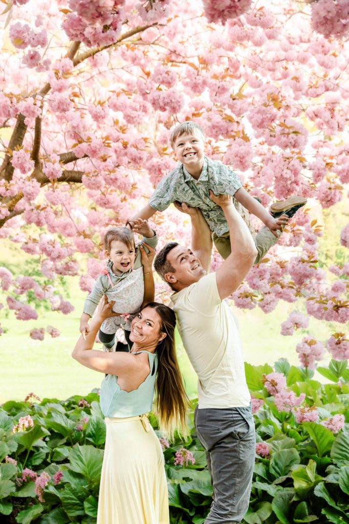 Familie genießt Frühlingstag unter blühendem Baum