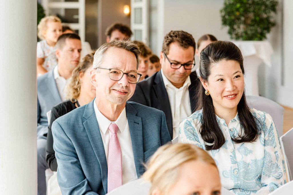 Personen lächeln bei festlicher Veranstaltung in Gruppe