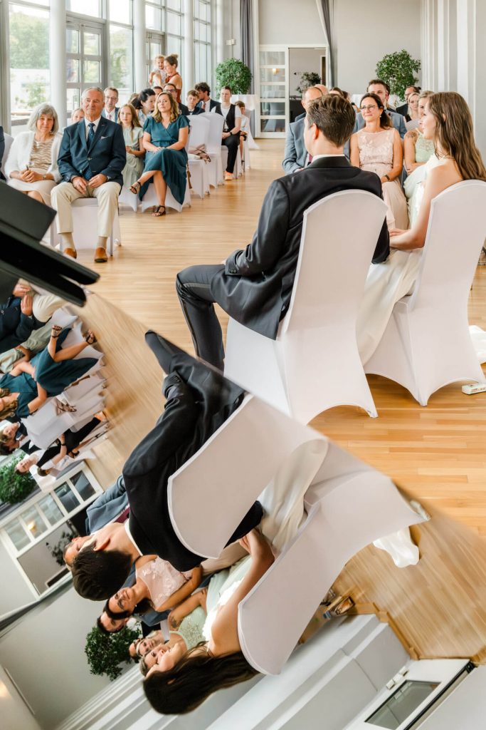 Hochzeitszeremonie mit Gästen in elegantem Saal