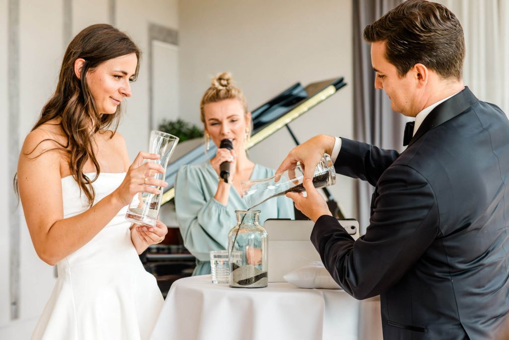 Brautpaar bei Hochzeit mit Trauzeugin beim Anstoßen