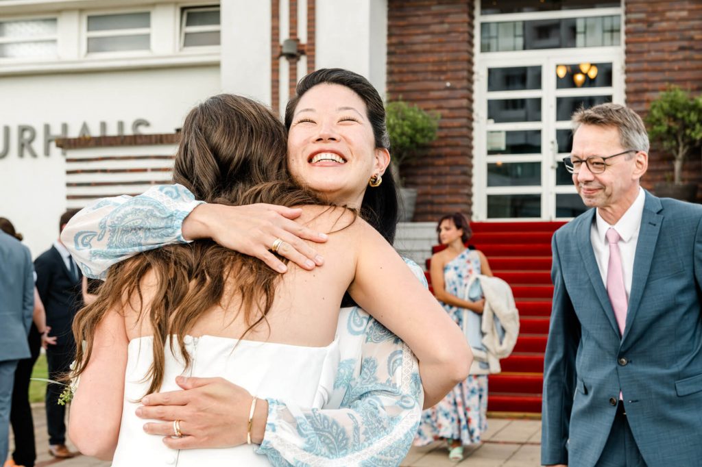 Menschen umarmen sich vor einem Gebäudeeingang