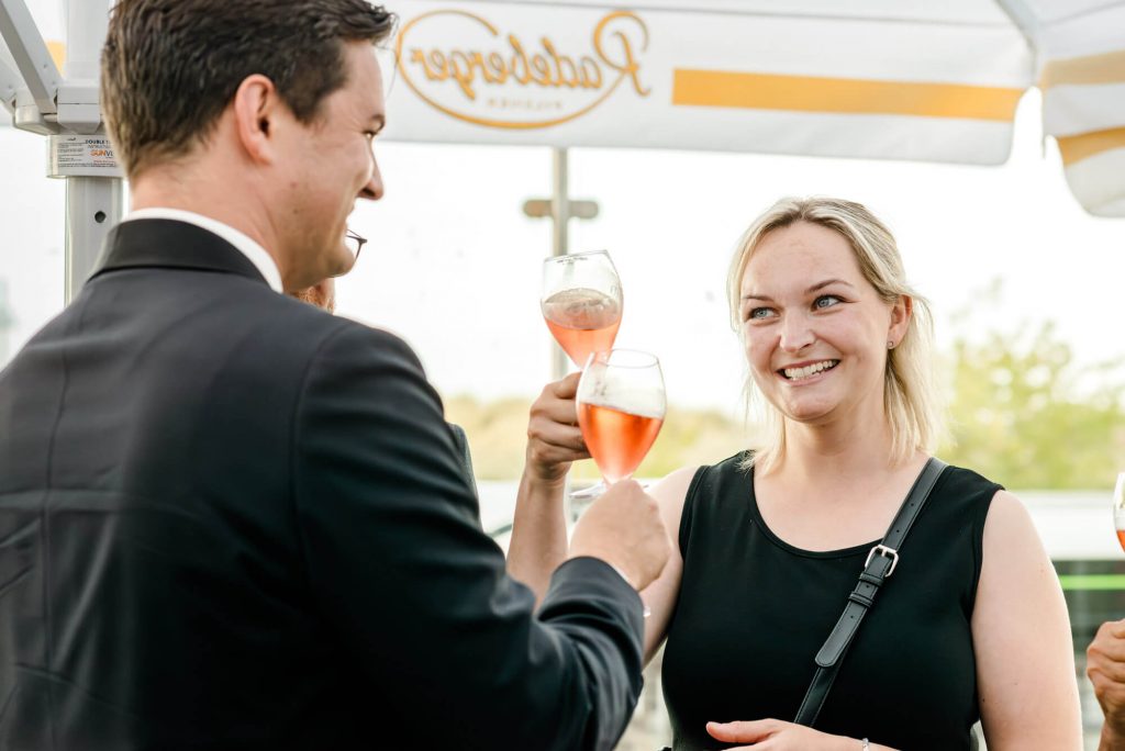 Personen genießen einen festlichen Sekt-Empfang draußen