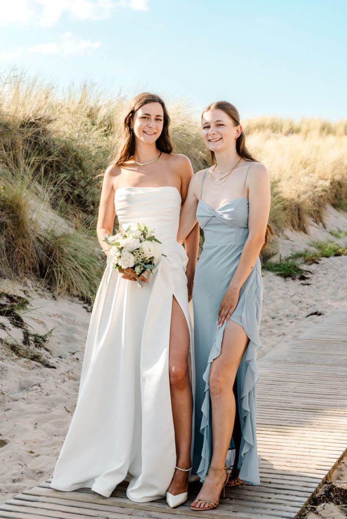 Zwei Frauen in eleganten Kleidern am Strand