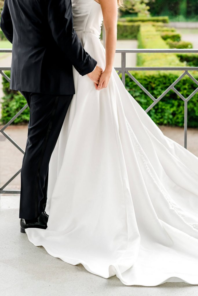 Brautpaar in eleganter Hochzeitskleidung auf Balkon