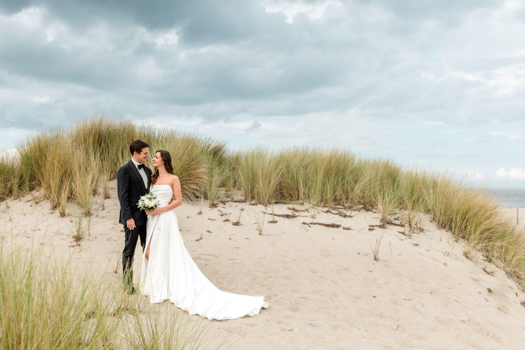 Brautpaar am Strand vor bewölktem Himmel
