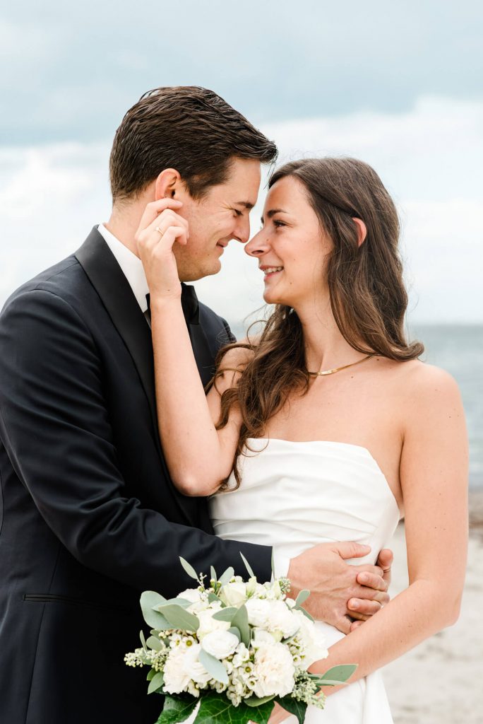 Glückliches Hochzeitspaar am malerischen Strand posiert