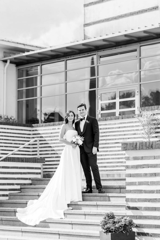Brautpaar auf Treppe vor moderner Architektur