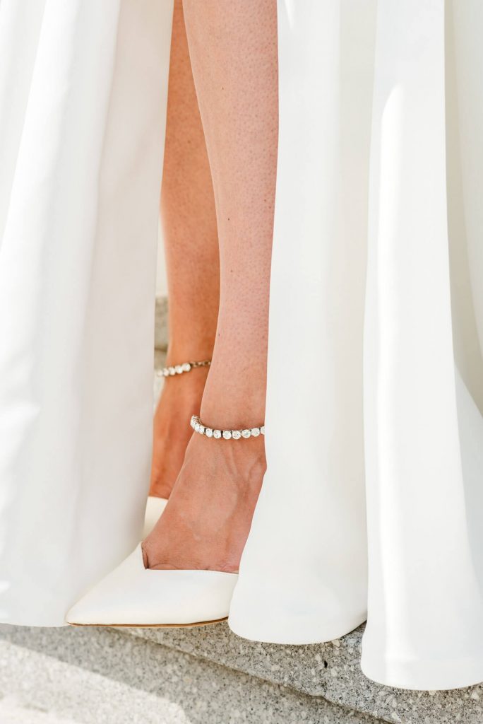 Brautkleid mit eleganten weißen Schuhen und Schmuck