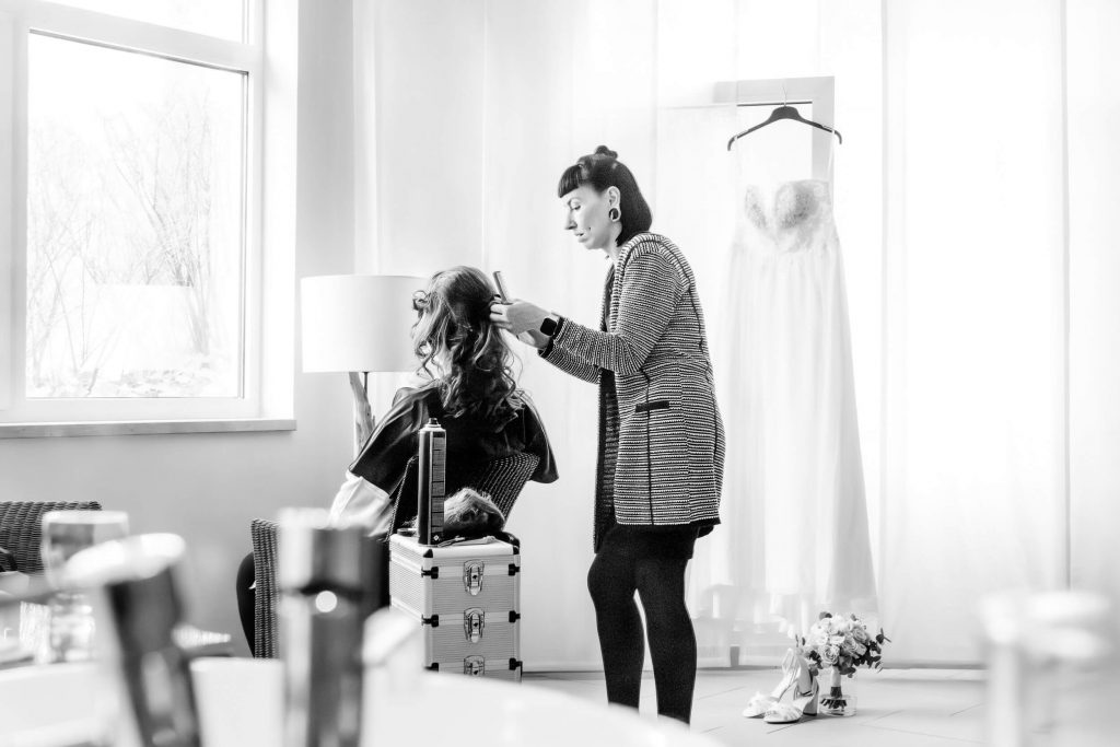 Friseur stylt Braut vor Hochzeit im Salon
