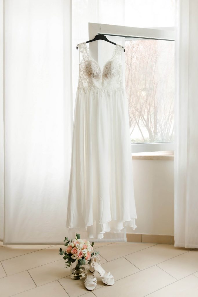 Brautkleid hängt im hellen Raumfenster
