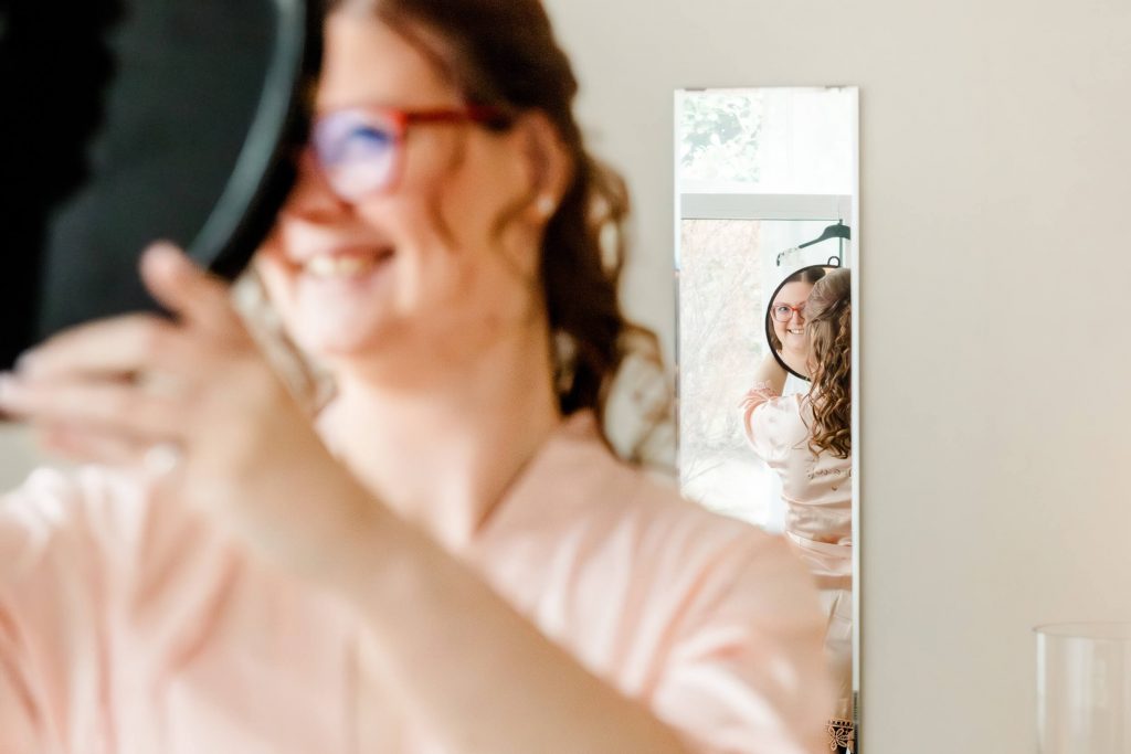 Frau lächelt in den Spiegel mit Locken.